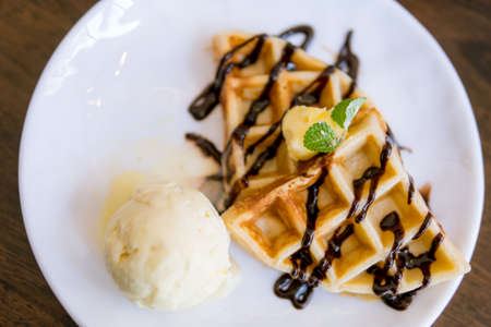Waffles with ice cream with chocolate and mint leafの写真素材