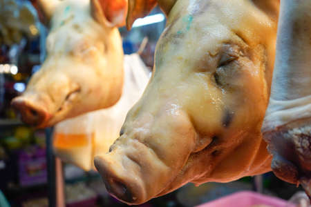 boiled pork heads hang in a butchers shopの写真素材