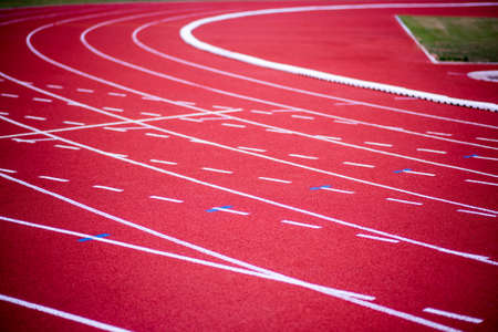 red rubber running racetrack with white lines in outdoor stadiumの写真素材