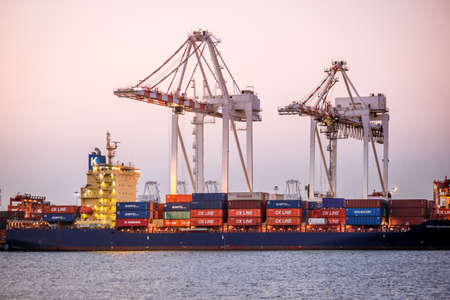 Chonburi, Thailand - February 18, 2018 : Loading cargo container ship port at twilight in Sriracha industrial port, Chonburi, Thailand.のeditorial素材