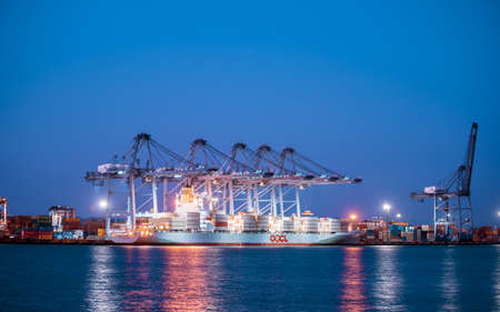 Chonburi, Thailand - February 18, 2018 : Loading cargo container ship port at twilight in Sriracha industrial port, Chonburi, Thailand.のeditorial素材