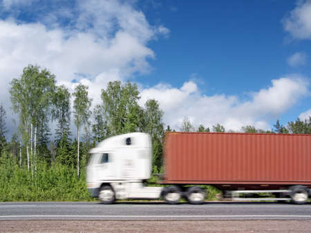 white container truck speeding on country highway, blured in motionの写真素材