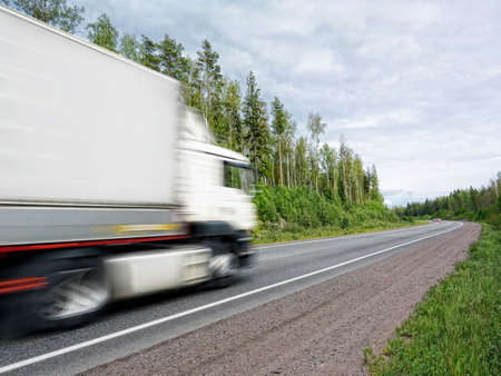 white truck speeding on country highway, blured in motionの写真素材