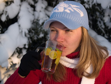 girl drinks tea near wood