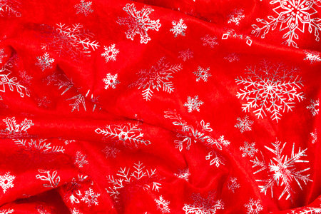 bright red velvet coat of Santa Claus with silvery shiny snowflakes. view from above