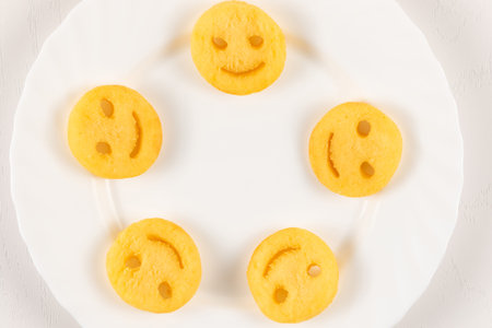fresh potato hot emoticons fries on white plate close-up on white wooden table backgroundの写真素材