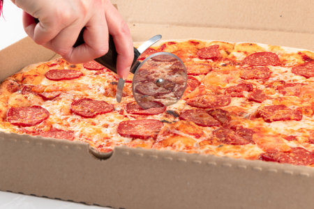 female hand cuts fresh aromatic hot Italian mozzarella pizza. close-upの写真素材