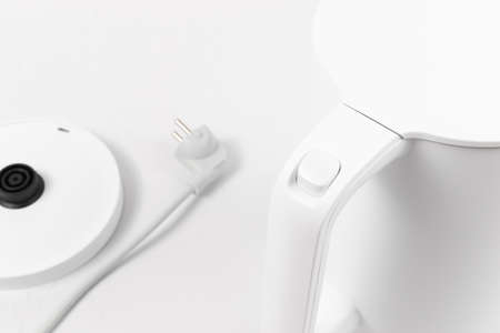 white electric kettle with lid lift button and switch on white backgroundの写真素材