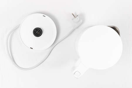 white electric kettle with lid lift button and switch on white backgroundの写真素材