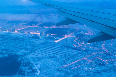top view from a height of flight on the night city from the window of the plane. part of an airplane...