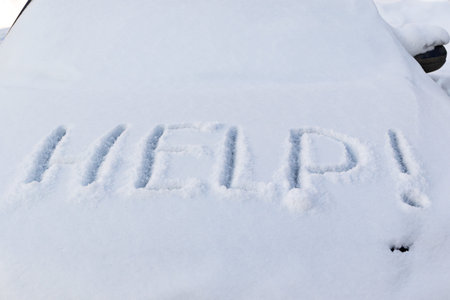 the inscription on the hood of a frozen broken car covered with snow, parked outside on a frosty...