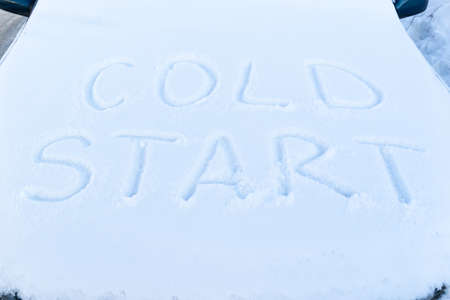 the inscription on the hood of a frozen broken car covered with snow, parked outside on a frosty winter day. the engine does not startの写真素材