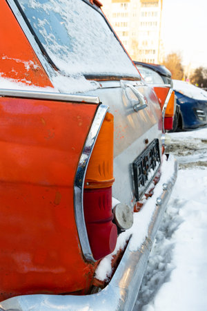 old broken vintage red rusty retro car parked in winter on snow background on frosty winter dayの写真素材