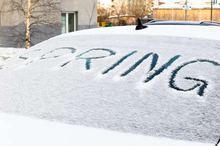 the inscription on the snow-covered rear window of the car spring on a bright sunny day. close-upの写真素材