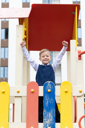 Cute boy first grader at school on the playground on a sunny autumn day. Celebration on September...