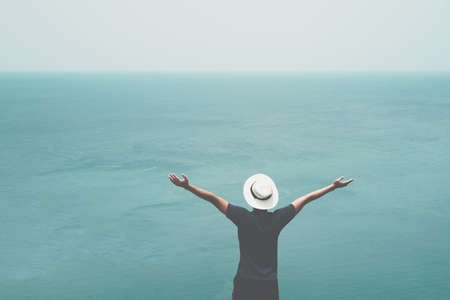 Man rise hands up to sky freedom concept with blue sky and summer ocean background.の写真素材