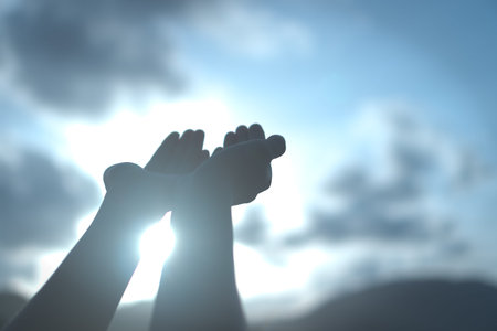 Woman hands place together like praying in front of nature green  background.の写真素材