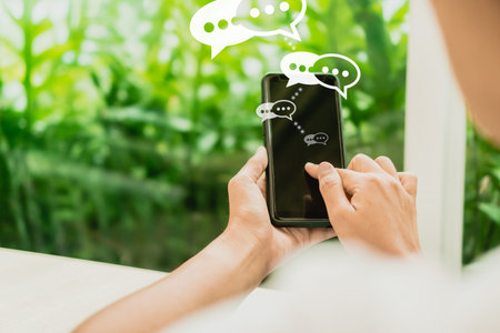 Women hand using smartphone typing, chatting conversation in chat box icons pop up. Social media...