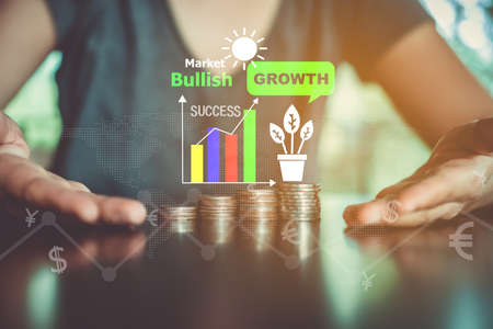 Business financial success concept. Gold coins on table and green nature bokeh background.の写真素材