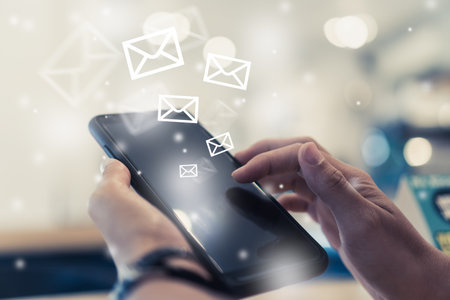 Woman hand using smartphone to send and recieve email for business on bokeh vintage color tone...