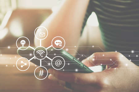 Communication fintech sign icon and connection screen of smartphone with blur cafe coffee shop background.の写真素材