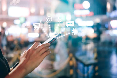 Women hand using smartphone do online selling for people shopping online with chat box, cart, dollar icons pop up.の写真素材