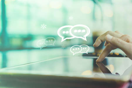 Women hand using smartphone typing, chatting conversation in chat box icons pop up.の写真素材