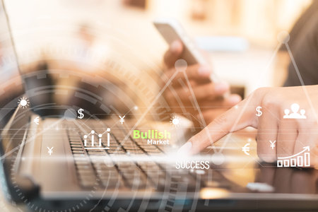 Woman's hand using smartphone and laptop to do business, financial or trading stock forex market ...