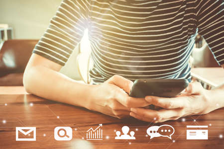 Communication fintech sign icon and market stock graph screen of smartphone with blur cafe coffee shop background. Financial business technology freedom dream life using internet freedom lifeの写真素材