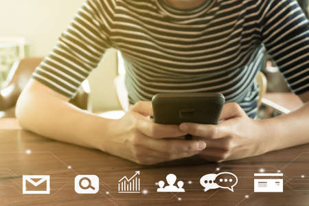 Communication fintech sign icon and market stock graph screen of smartphone with blur cafe coffee shop background. Financial business technology freedom dream life using internet freedom lifeの写真素材