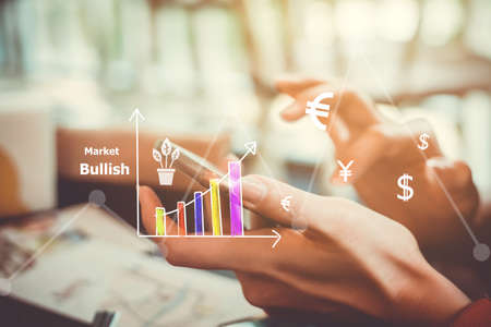 Fintech various currencies sign icon and market stock graph screen of smartphone with colorful bokeh blur background. Financial business technology freedom dream life using internet concept.の写真素材