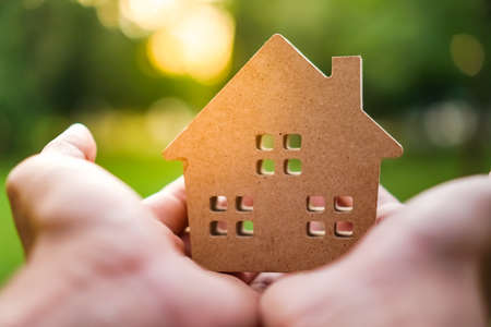 Hand hold house model on green nature background. Success dream life concept.の写真素材