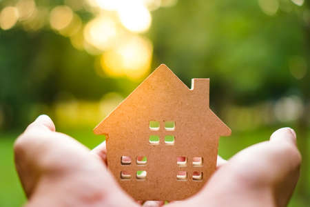 Hand hold house model on green nature background. Success dream life concept.の写真素材