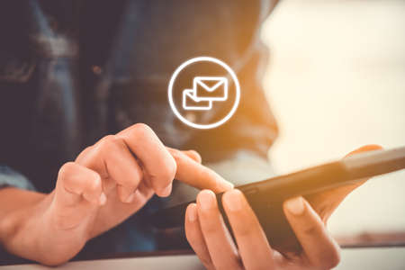 Woman hand using smartphone to send and recieve email. Business communication  technology concept.の写真素材