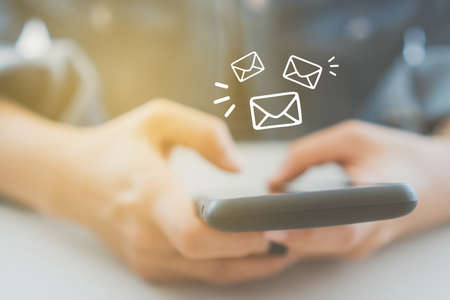 Woman hand using smartphone to send and recieve email. Business communication  technology concept.の写真素材