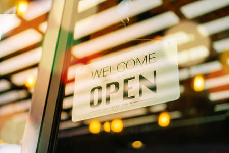 A business sign that says âOpenâ on cafe or restaurant hang on door at entrance. Vintage color tone style.の写真素材