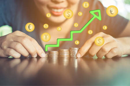 Business financial success concept with icons of success word screen on picture of woman is smiling feel happy and freedom. Gold coins set on table.の写真素材