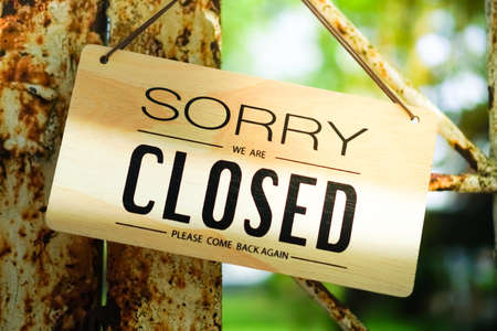 A Sign board of sorry we are closed hang on door of business shop with nature green backgroundの写真素材