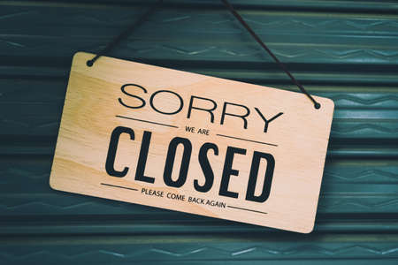 A Sign board of sorry we are closed hang on door of business shop background.の写真素材