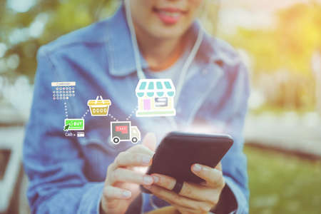 Women hand using smartphone do shopping online store with various doodle icons pop up. Social media maketing concept.の写真素材