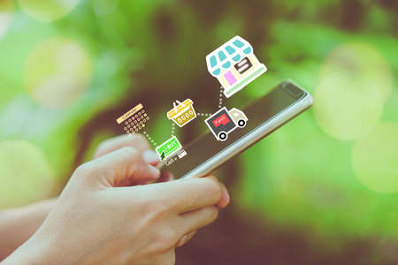 Women hand using smartphone do shopping online store with various doodle icons pop up. Social media maketing concept.の写真素材