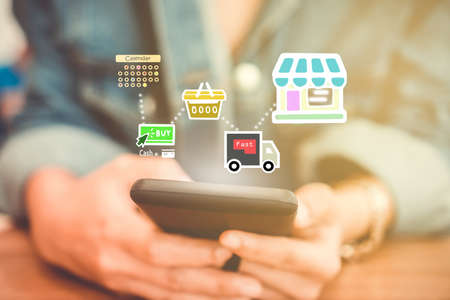Women hand using smartphone do shopping online store with various doodle icons pop up. Social media maketing concept.の写真素材
