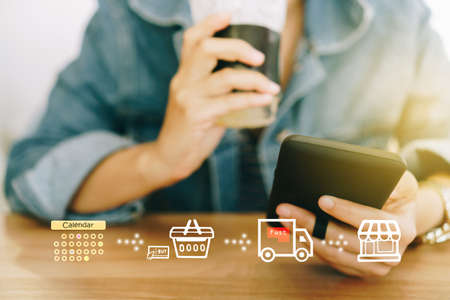 Women hand using smartphone do shopping online store with various doodle icons pop up. Social media maketing concept.の写真素材