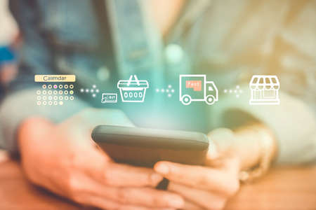Women hand using smartphone do shopping online store with various doodle icons pop up. Social media maketing concept.の写真素材