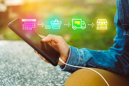 Women hand using smartphone do shopping online store with various doodle icons pop up. Social media maketing concept.の写真素材