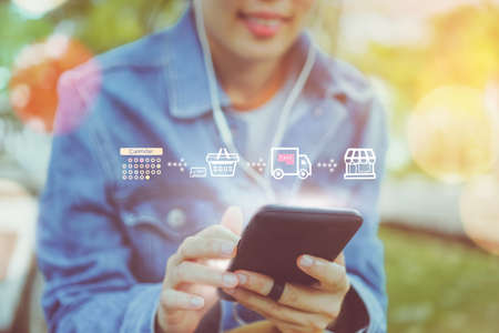 Women hand using smartphone do shopping online store with various doodle icons pop up. Social media maketing concept.の写真素材