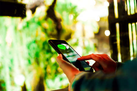 Women hand using smartphone typing, chatting conversation in chat box icons pop up. Social media maketing technology concept.Vintage soft color tone background.の写真素材