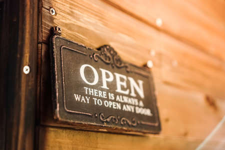 A business sign that says âOpenâ on cafe or restaurant hang on door at entrance. Vintage color tone style.の写真素材