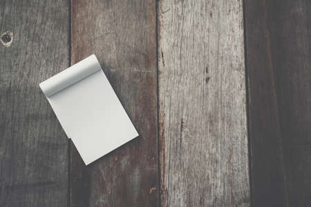 Small white notebook on old grunge wood texture background.の写真素材