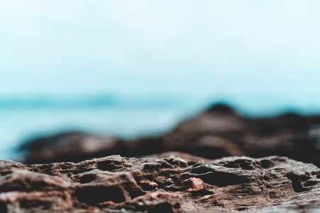 Selective focus od black stone texture for put product to show with beach in background.の写真素材